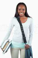 Smiling young student with books and bag