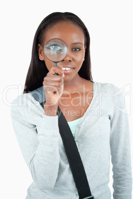 Smiling young woman with magnifier