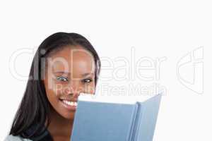 Side view of smiling woman reading a book