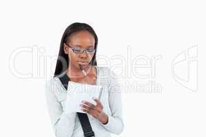 Young woman with glasses reading her notes