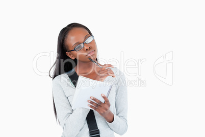 Young woman with glasses and notepad in thoughts