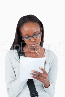 Young woman with glasses on taking notes