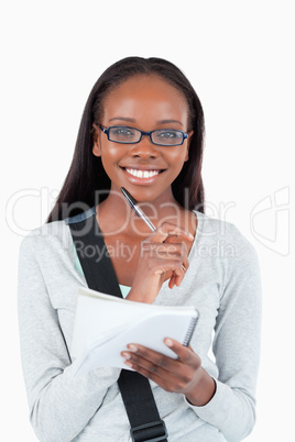 Smiling young woman with glasses and notepad