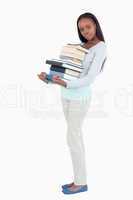 Side view of young woman with a pile of books