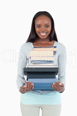 Smiling young woman with a pile of books Smiling young woman with a pile of books
