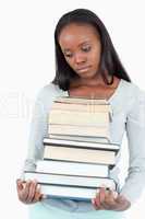 Sad woman with pile of books looking to the side