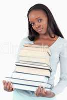 Sad smiling woman with pile of books