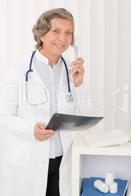 Senior doctor female hold x-ray and phone