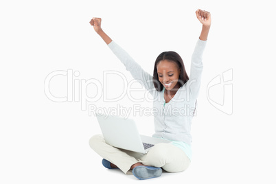 Young woman stretching while on the floor with her laptop