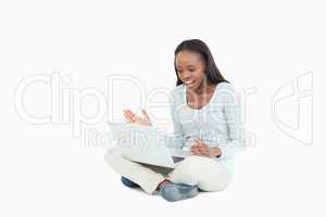 Young woman on the floor yelling at her laptop