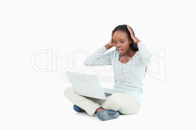 Young woman on the floor surprised by her laptop