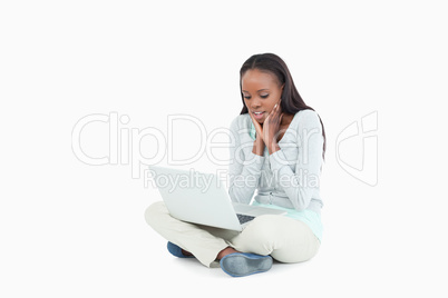Young woman on the floor seems skeptical about her laptop