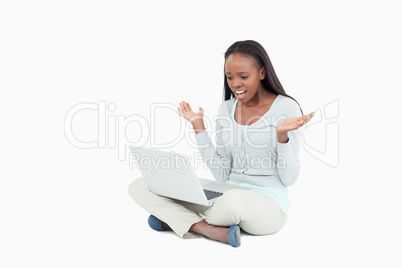 Young woman on the floor negative surprised by her laptop