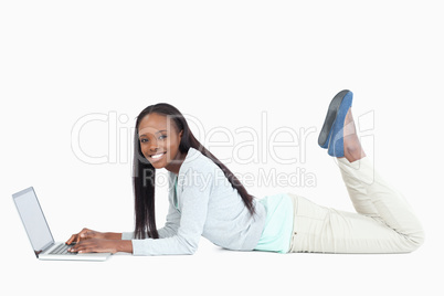 Side view of woman on the floor with her laptop