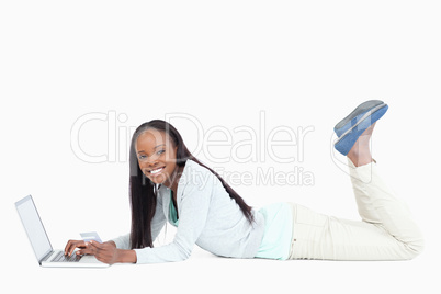 Side view of woman lying on the floor with her notebook