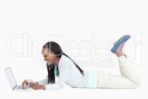Side view of smiling woman on the floor with her laptop