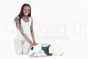 Smiling young woman putting cloth in her trunk