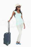Young woman with sunglasses, hat and suitcase
