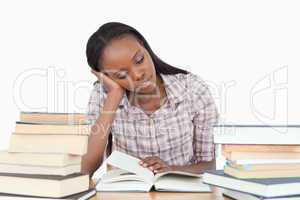 Young woman almost falling asleep while reading