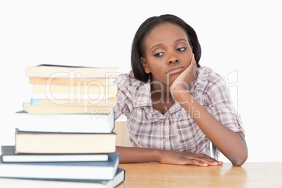 Bored student looking at a stack of books