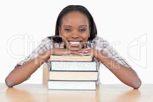Student with her chin on a stack a book