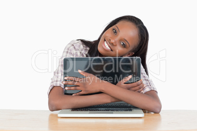 Young woman hugging her laptop