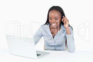 Businesswoman making a phone call while using a notebook