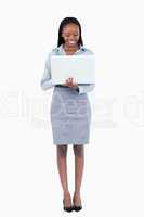 Portrait of a smiling businesswoman using a laptop while standin