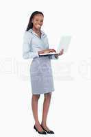 Portrait of a happy businesswoman using a laptop while standing