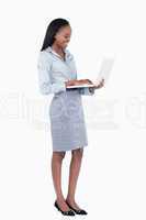 Portrait of a cute businesswoman using a laptop while standing u