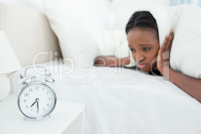 Woman being awakened by her alarm clock