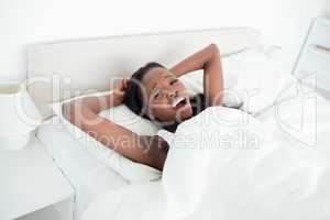 Woman yawning on her bed