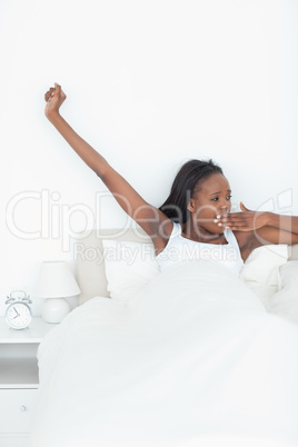 Portrait of a woman stretching her arms and yawning