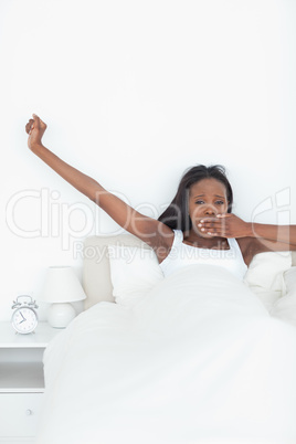 Portrait of a woman stretching her arms while yawning