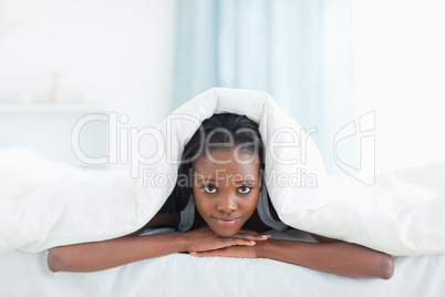 Woman posing under a duvet