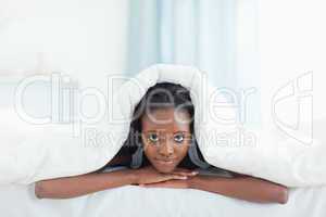 Woman posing under a duvet