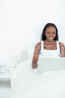 Portrait of a young woman using a notebook before sleeping