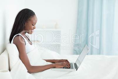 Young woman using a notebook before sleeping