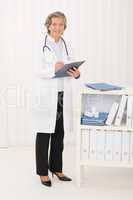 Senior doctor female stand in office portrait