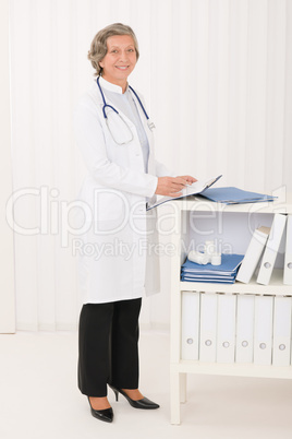 Senior doctor female stand in office portrait