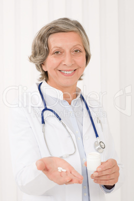 Medical doctor senior female hold pills smiling