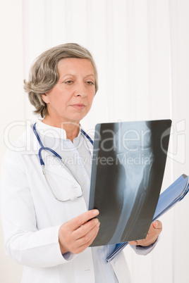 Senior doctor female looking at x-ray