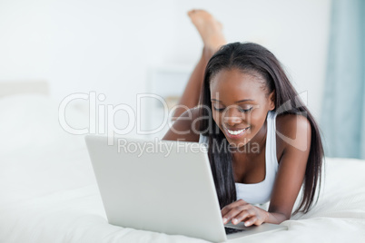 Woman lying on her belly using a laptop