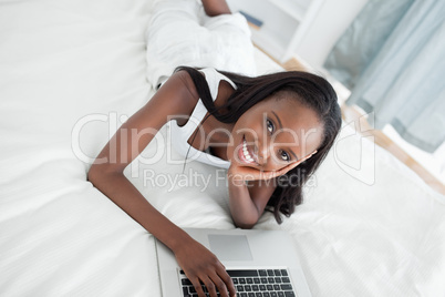 Young woman lying on her belly using a notebook