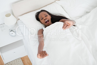 Tired woman stretching her arms and yawning