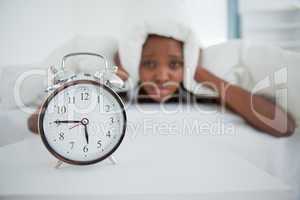 Woman being awakened by her alarm clock in her bedroom