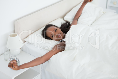 Woman stretching her arms while waking up