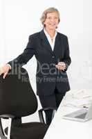 Senior businesswoman smile stand behind office desk
