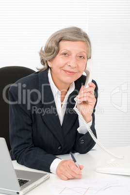 Senior businesswoman smile sit behind office desk