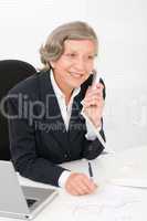 Senior businesswoman smile sit behind office desk